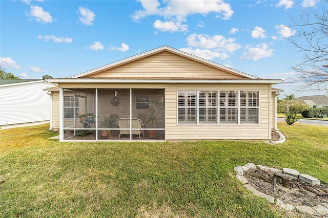 back of house featuring a sunroom and a lawn