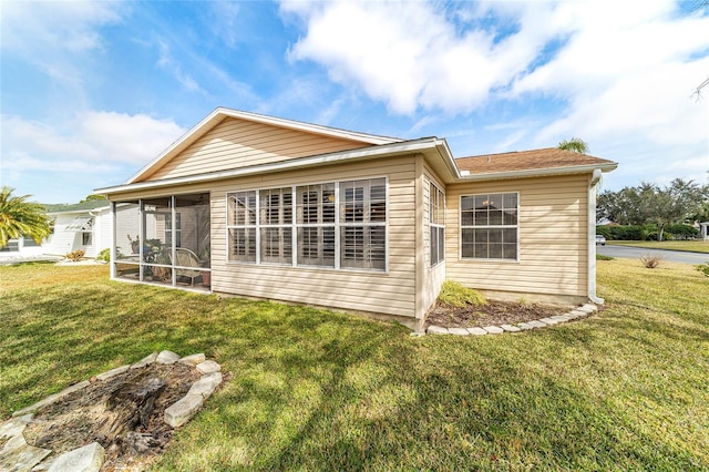 back of house with a sunroom and a lawn