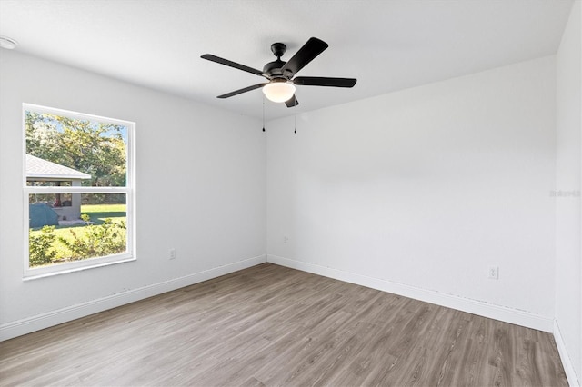 spare room featuring ceiling fan, a healthy amount of sunlight, and light wood-type flooring