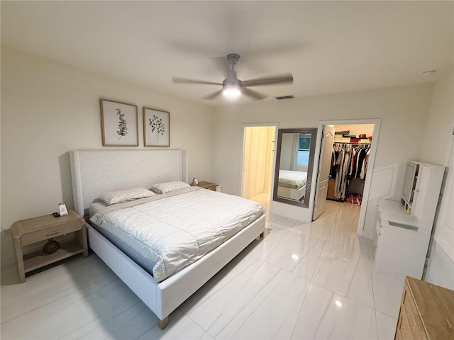 bedroom featuring ceiling fan, a walk in closet, and a closet