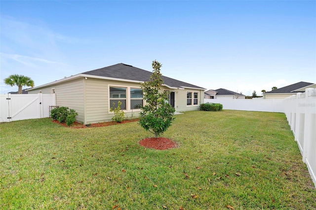 rear view of property featuring a lawn