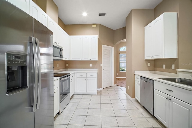 kitchen with light tile patterned floors, white cabinets, and appliances with stainless steel finishes