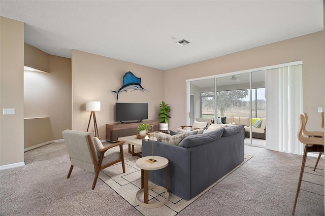 carpeted living room with ceiling fan