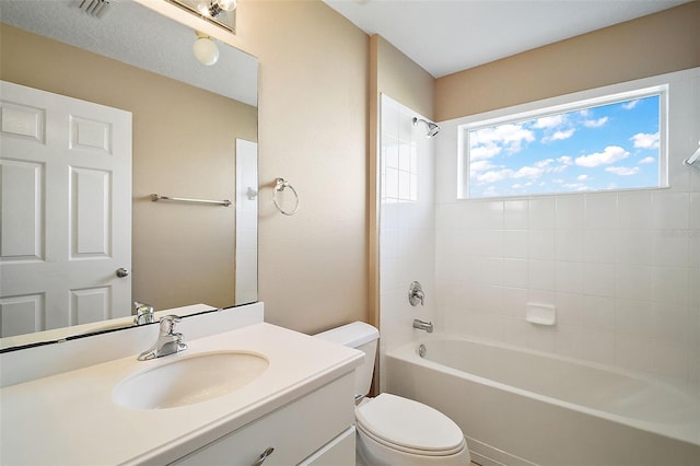 full bathroom with tiled shower / bath combo, vanity, and toilet