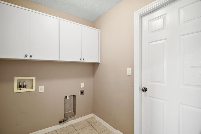 laundry room with cabinets, a textured ceiling, light tile patterned floors, washer hookup, and hookup for an electric dryer