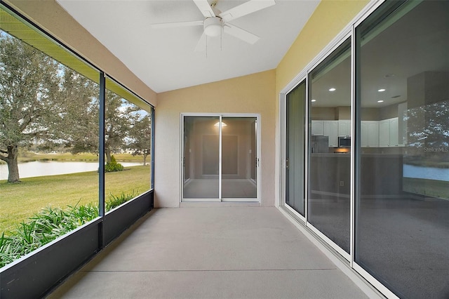 unfurnished sunroom featuring a water view, ceiling fan, and vaulted ceiling