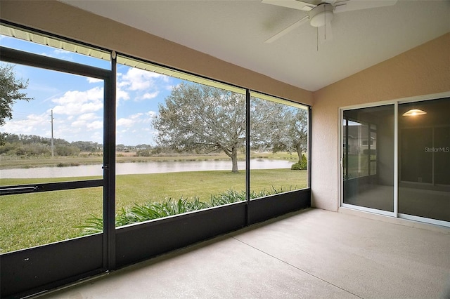 unfurnished sunroom featuring a water view, ceiling fan, and lofted ceiling