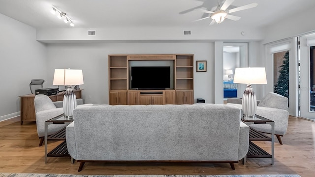 living room with ceiling fan, rail lighting, and wood-type flooring