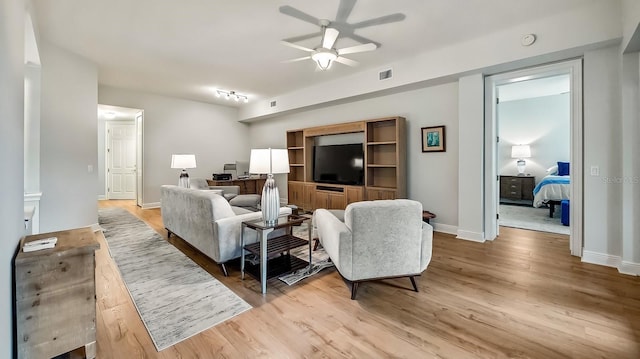 living room featuring ceiling fan and light hardwood / wood-style flooring