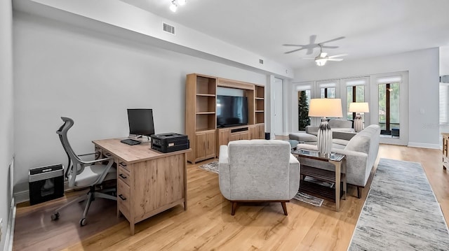 living room featuring light hardwood / wood-style floors, french doors, and ceiling fan