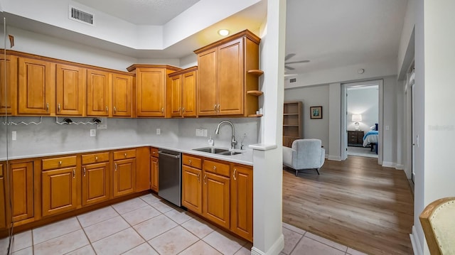 kitchen with light tile patterned floors, ceiling fan, backsplash, dishwasher, and sink