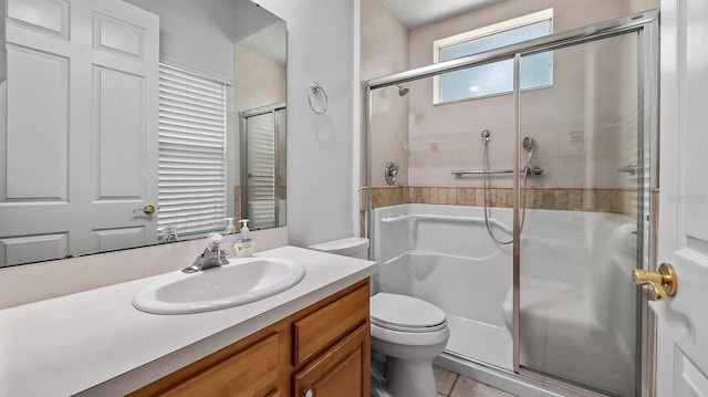 bathroom with tile patterned flooring, toilet, walk in shower, and vanity