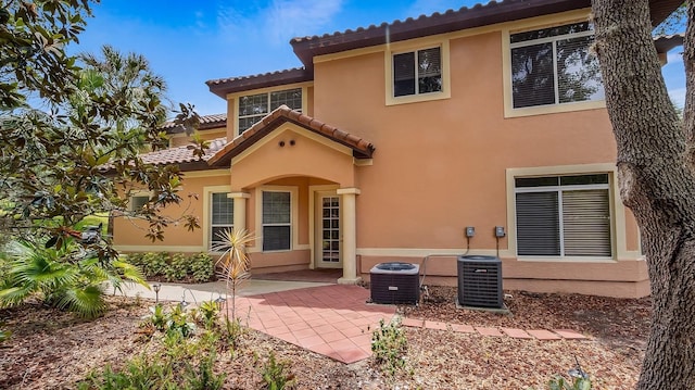 back of property featuring cooling unit and a patio