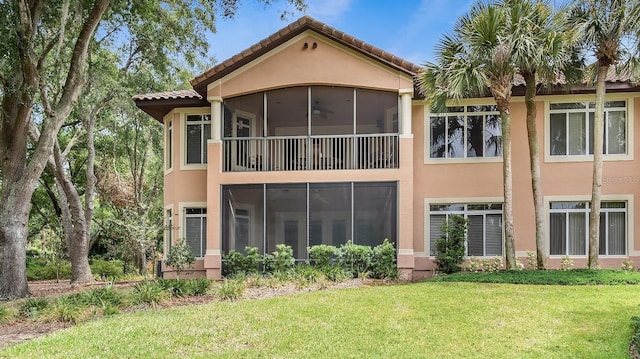 back of property with a lawn and ceiling fan