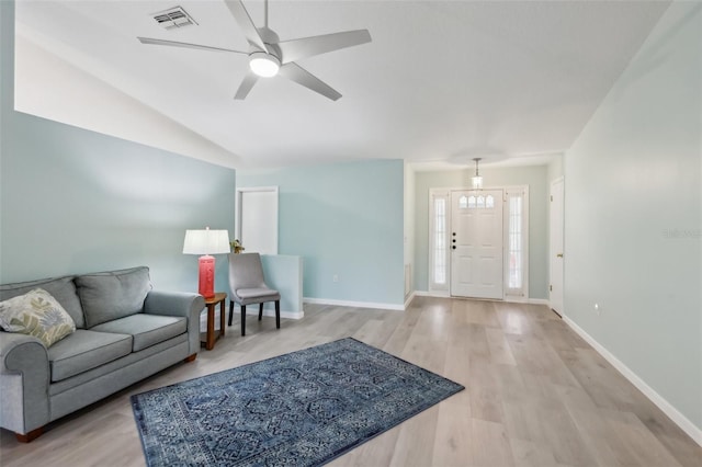 living room with ceiling fan, light wood-type flooring, and vaulted ceiling