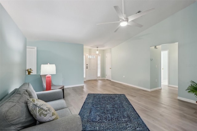 living room featuring light wood-type flooring, ceiling fan, and high vaulted ceiling