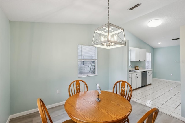 dining room with light tile patterned floors, lofted ceiling, and sink