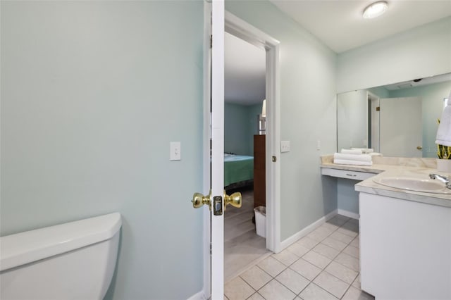 bathroom with toilet, vanity, and tile patterned floors