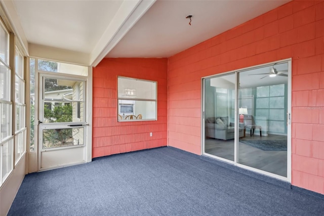 unfurnished sunroom with ceiling fan and vaulted ceiling