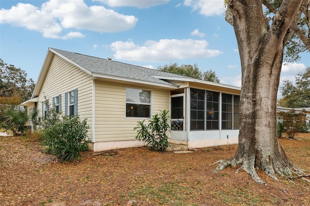 rear view of house featuring a sunroom