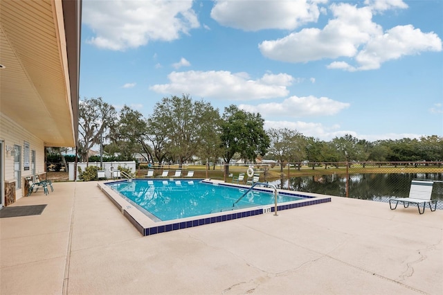 view of swimming pool with a water view and a patio