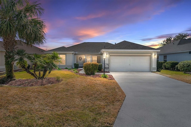 single story home featuring a garage and a yard