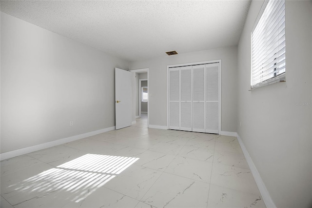 unfurnished bedroom with a closet and a textured ceiling