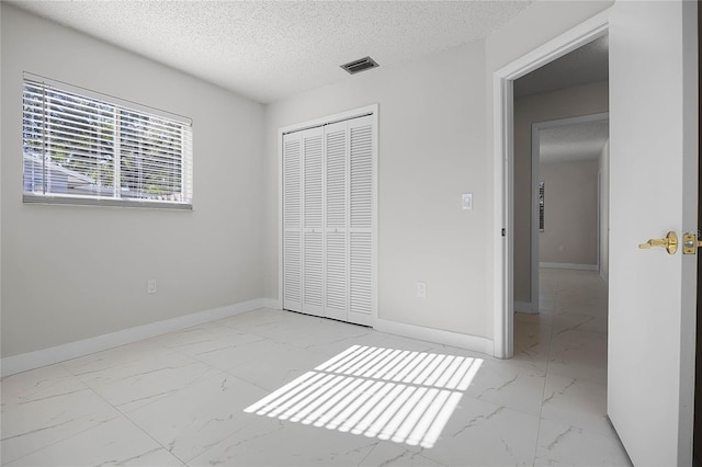 unfurnished bedroom with a closet and a textured ceiling