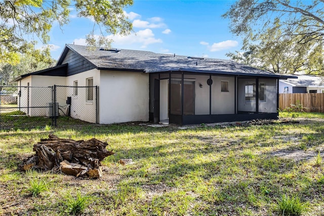 rear view of property with a sunroom and a yard