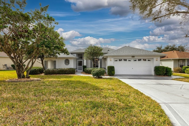single story home with stucco siding, an attached garage, concrete driveway, and a front yard