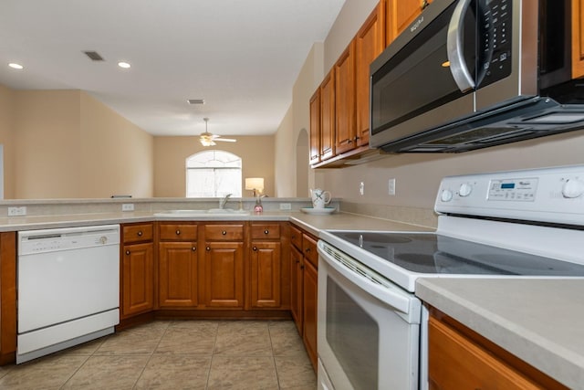 kitchen with white appliances, sink, kitchen peninsula, ceiling fan, and light tile patterned floors