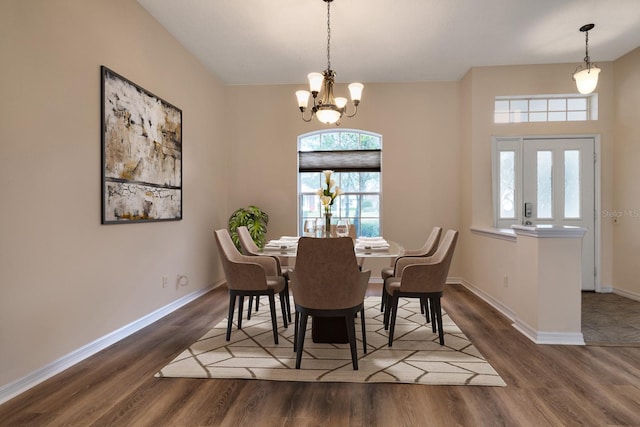 dining area featuring wood-type flooring and a notable chandelier