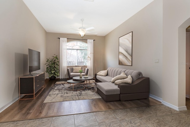 living room featuring ceiling fan and dark tile patterned floors