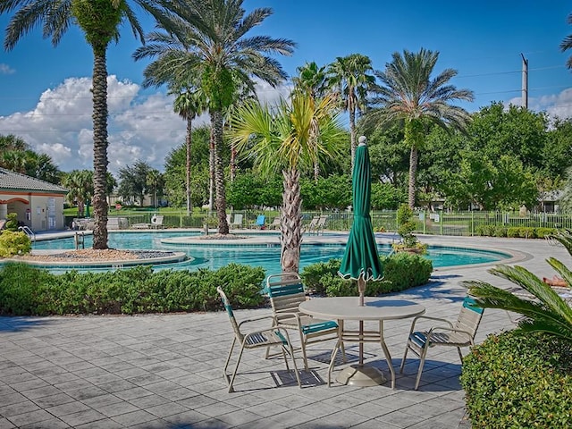 community pool featuring fence and a patio area