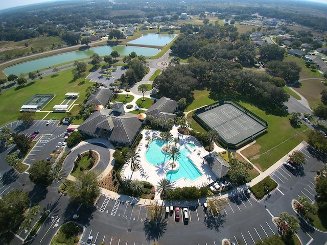 aerial view of property and surrounding area with a pool and a nearby body of water