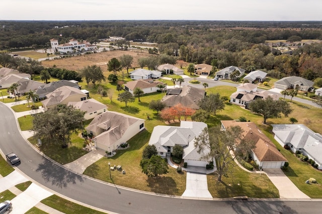 aerial overview of property's location featuring nearby suburban area and a forest