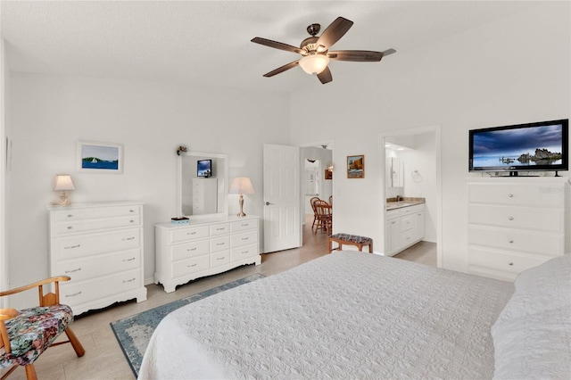 bedroom with ceiling fan, lofted ceiling, and connected bathroom