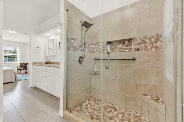 bathroom featuring walk in shower, vanity, and tile patterned flooring