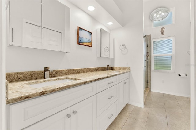 bathroom featuring a shower with door, vanity, and tile patterned flooring