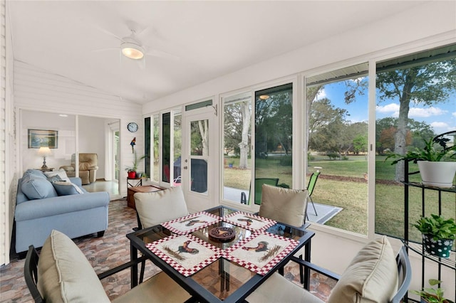 sunroom / solarium with vaulted ceiling, a healthy amount of sunlight, and ceiling fan