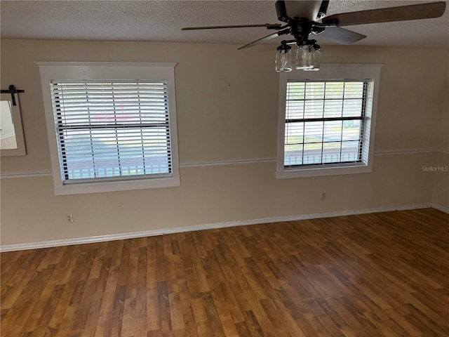 spare room with ceiling fan, a textured ceiling, and wood-type flooring