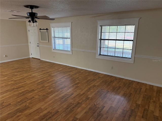 unfurnished room featuring ceiling fan, a textured ceiling, and dark hardwood / wood-style flooring