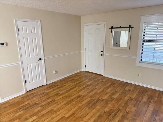 unfurnished room with a textured ceiling and hardwood / wood-style floors