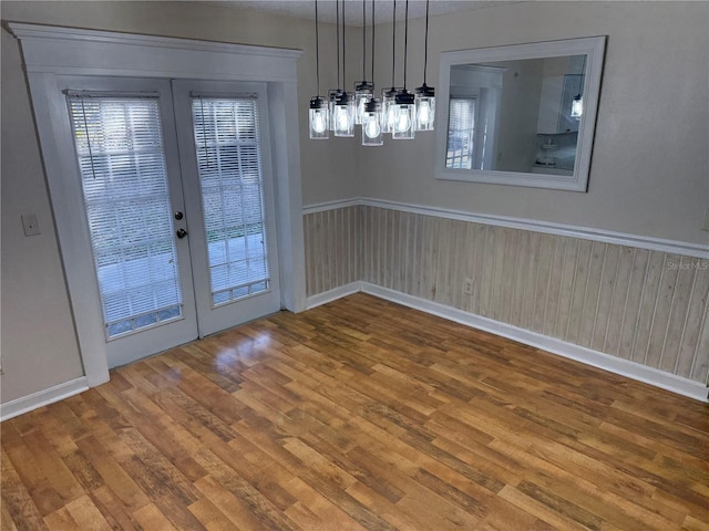 unfurnished dining area featuring hardwood / wood-style floors and french doors