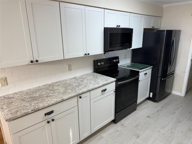 kitchen featuring light stone counters, decorative backsplash, white cabinets, and black appliances