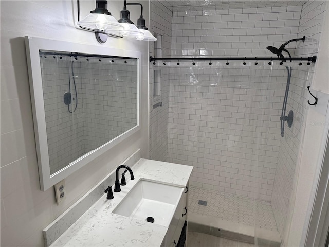 bathroom featuring a tile shower and vanity