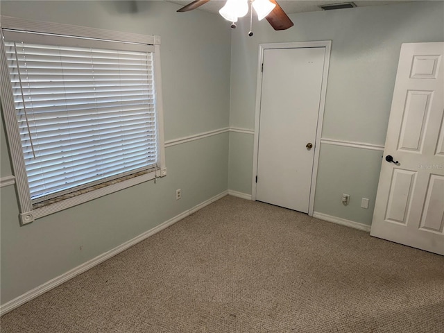 unfurnished bedroom featuring ceiling fan, a closet, and light carpet