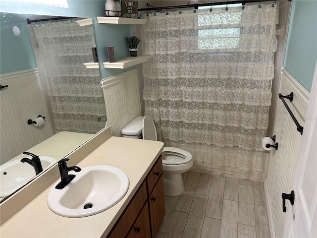 bathroom with toilet, vanity, and a shower with curtain