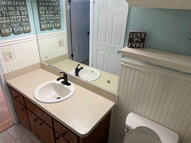 bathroom with toilet, vanity, and tile patterned flooring