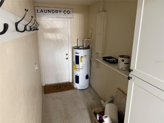 utility room featuring electric panel and water heater